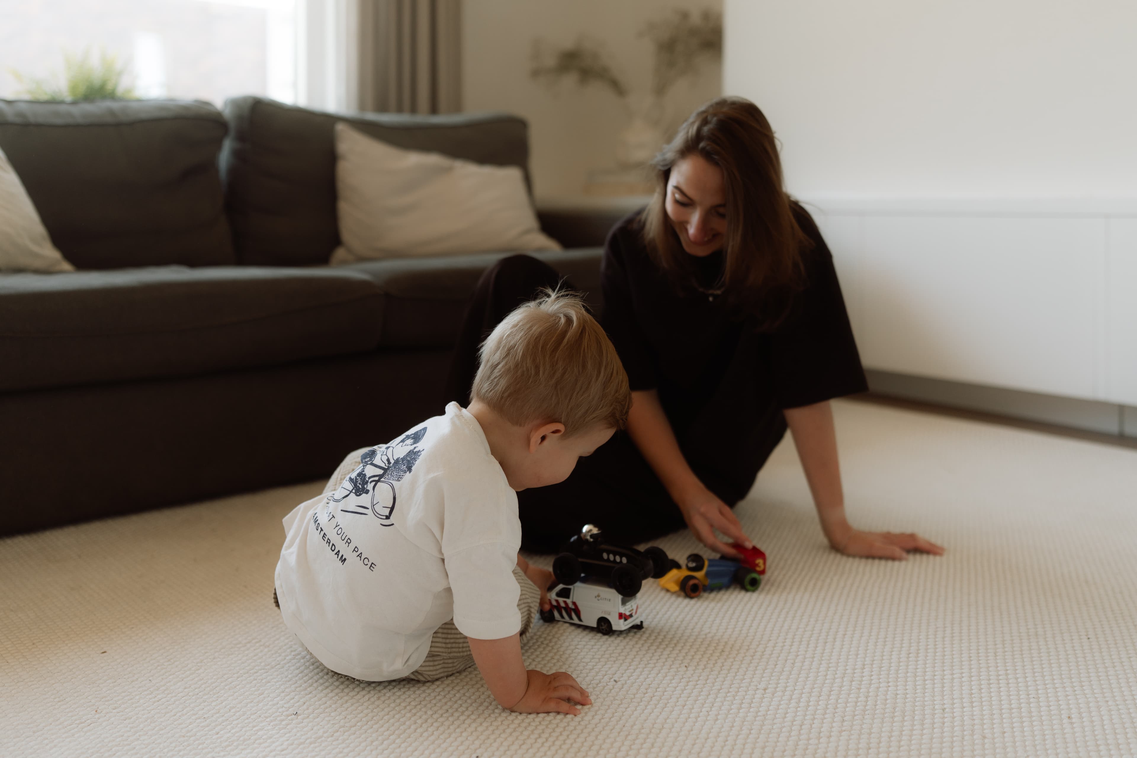 Een moeder speelt met haar zoontje op de grond